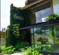 a building with a lot of plants and a sign that says mamata